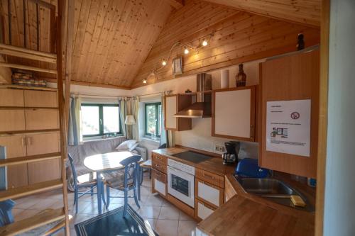 eine Küche in einem winzigen Haus mit einem Tisch in der Unterkunft Hof Marienberg, 56340 Osterspai, Deutschland Wanderhütte in Osterspai