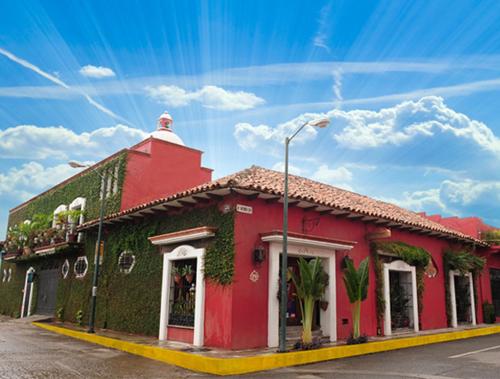 a red building with ivy on the side of it at Hotel Boutique Casona Maya Mexicana in Tapachula