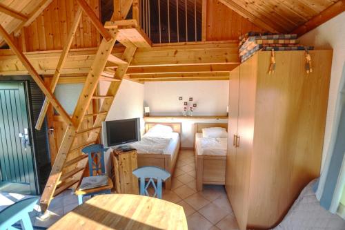 Kleines Zimmer mit einem Bett und einem Schreibtisch mit einem Computer. in der Unterkunft Hof Marienberg, 56340 Osterspai, Deutschland Wanderhütte in Osterspai
