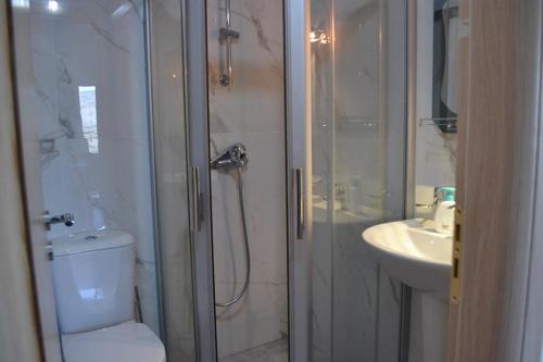 a bathroom with a shower and a toilet and a sink at Villa Melodia Xhek in Ksamil
