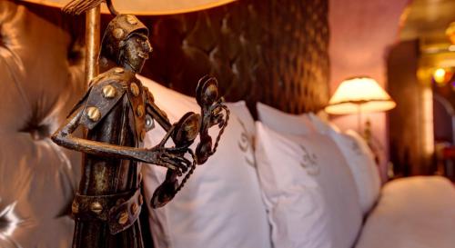 a wooden statue of a man next to a bed at Riad Wow in Marrakesh