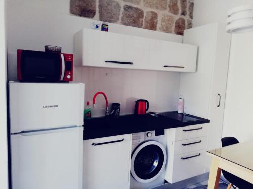 a kitchen with a refrigerator and a washing machine at Zanicovo beach apartment in Komiža