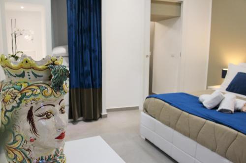 ein Schlafzimmer mit einem Bett mit einer Statue einer Frau mit einer Krone in der Unterkunft CIVITAS in Catania
