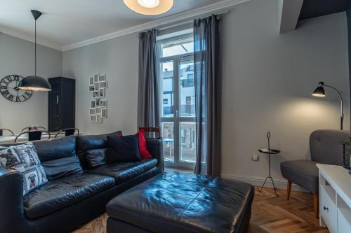 uma sala de estar com um sofá de couro preto e uma janela em Midnight Blue em Burgas