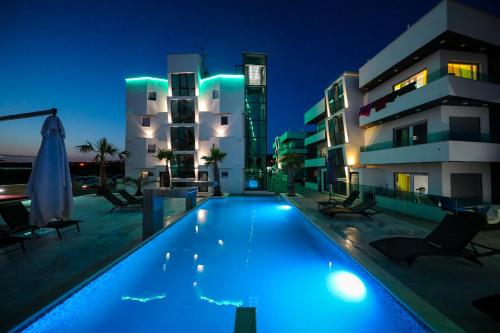 a swimming pool in front of a building at night at Boutique Residence Cosmopolis 1 in Bibinje