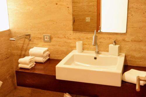 een badkamer met een wastafel, een spiegel en handdoeken bij OportoNature in Guilhabreu