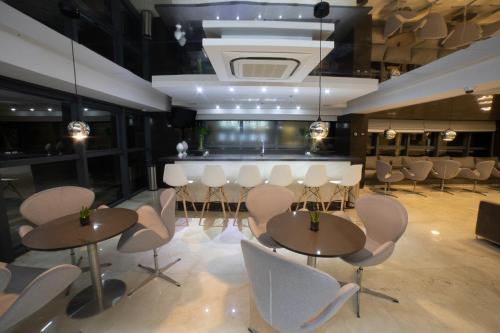 a restaurant with tables and chairs and a bar at Intercity Campina Grande Citymix in Campina Grande
