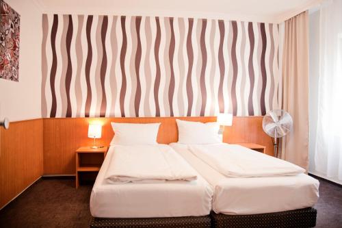 a hotel room with two beds and a striped wall at Les Nations in Berlin