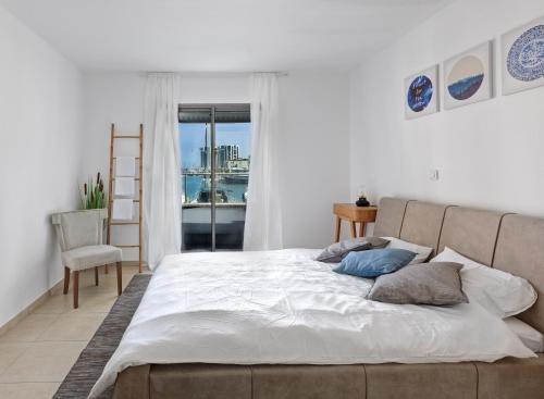 een slaapkamer met een groot bed en een raam bij Lagoon Water Front Suite in Herzliyya B