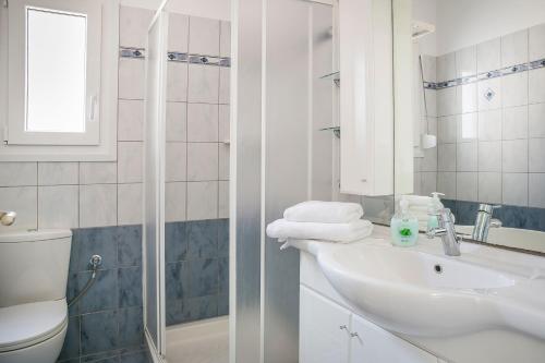 Un baño blanco con lavabo e inodoro. en Countrystyle Villa Bonora, en Skala