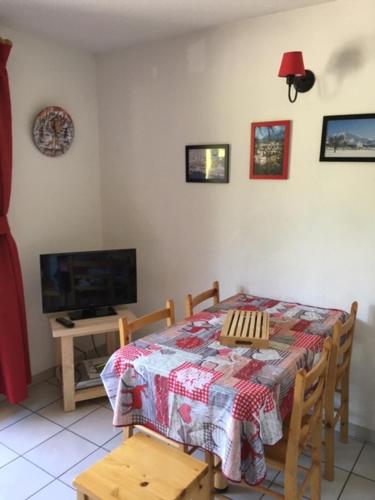 comedor con mesa y TV en L appart' du bonheur en Ancelle