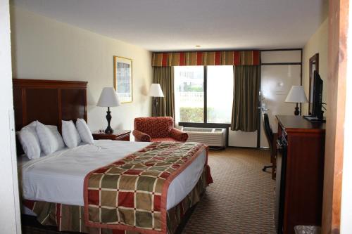 ein Hotelzimmer mit einem Bett, einem Schreibtisch und einem Fenster in der Unterkunft Great Smokies Inn - Cherokee in Cherokee