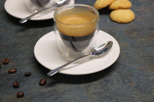 a cup of coffee on a plate with coffee beans at Hotel Macun, Vent im Ötztal in Vent