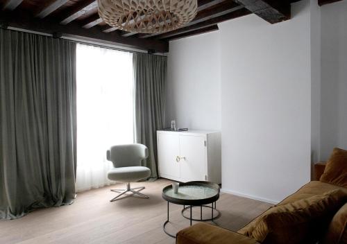 een woonkamer met een bank, een tafel en een stoel bij The Greenhouse in Antwerpen