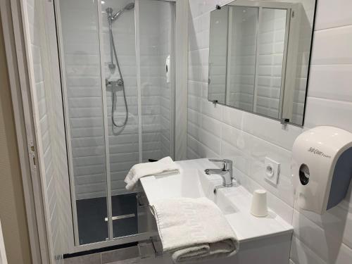 La salle de bains blanche est pourvue d'une douche et d'un lavabo. dans l'établissement Astrotel Romorantin-Lanthenay Soirée étape, à Romorantin-Lanthenay