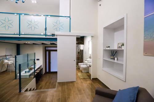 een woonkamer met een bank en een badkamer bij La Stella Di Ortigia in Siracusa