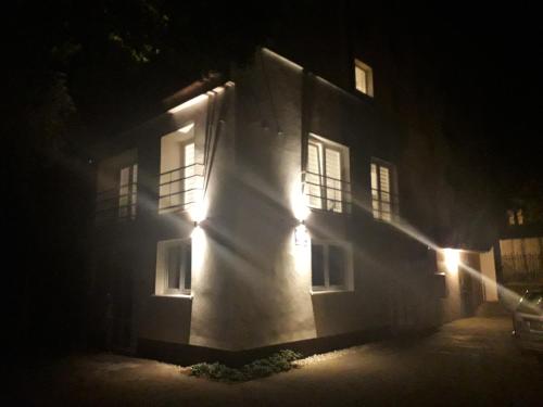 a building with lights on the side of it at night at Sol De Sopot in Sopot