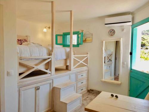 sypialnia z 2 łóżkami piętrowymi i lustrem w obiekcie Kathys Island Retreat w mieście Adia