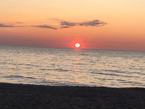 a sunset on the beach with the sun setting at Manor Motel in Southampton