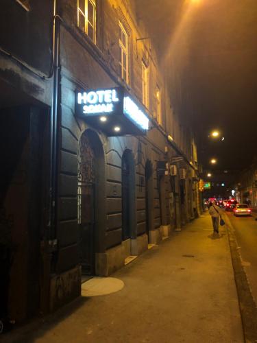 un cartel en un edificio en una calle por la noche en Antwerp apartments, en Sarajevo