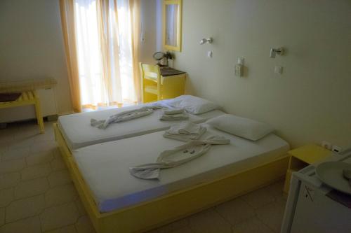 イライオンにあるSpiti Hotelのベッドルーム1室(白いシーツ付きのベッド1台、窓付)