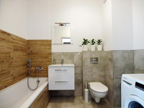 uma casa de banho com um WC, um lavatório e uma banheira em Airport Residence Blue em Varósvia