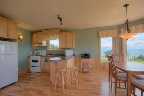 a kitchen with wooden cabinets and a table and chairs at Domaine Frais Air in La Malbaie