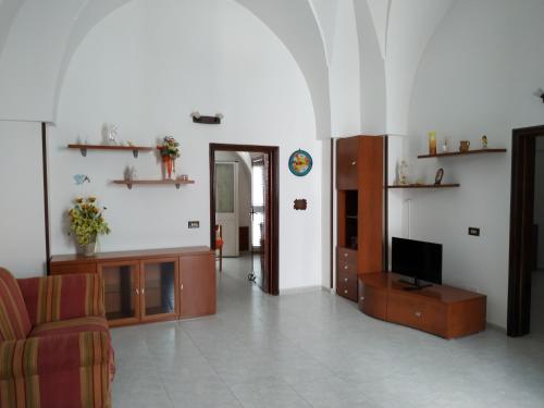 sala de estar con sofá y TV en Casa Sosò, en Maruggio