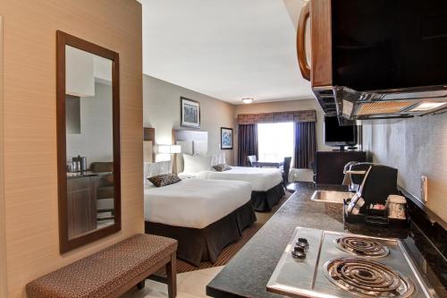 a hotel room with a bedroom with a bed and a kitchen at Canalta Hotel Esterhazy in Esterhazy
