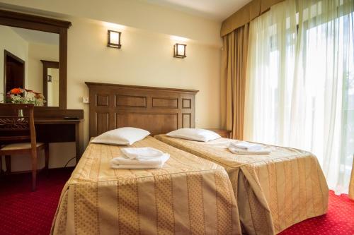 a hotel room with two beds with towels on them at Hanul Bran in Bran