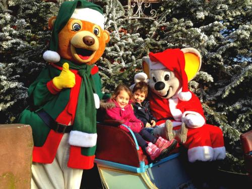 a group of children riding on a sesame street christmas parade at Hôtel Le Manoir in Barr