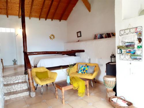 a bedroom with a bed and chairs in a room at Casa ALMA in Hermigua
