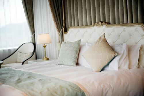 a bedroom with a white bed with pillows at Hotel Monterey Himeji in Himeji