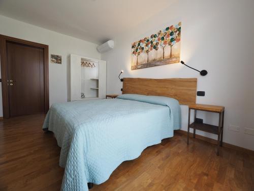 a bedroom with a bed with a blue bedspread at B&B Ca' Restom in Reggio Emilia