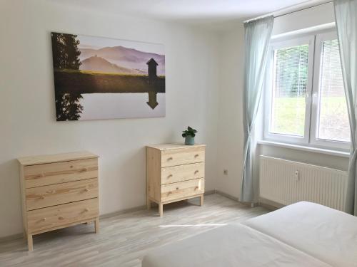 ein Schlafzimmer mit einem Bett, einer Kommode und einem Fenster in der Unterkunft Apartmán Hodruša-Hámre in Hodruša