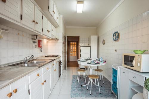 a kitchen with a sink and a table with chairs at Bela Vista in Viana do Castelo