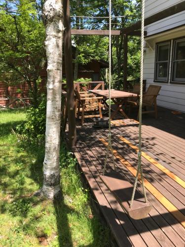 a porch with a picnic table and a swing at Vegetarian House Jamoo in Yamanakako