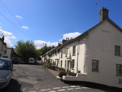 a row of white houses on a street at Church View House in Drewsteignton