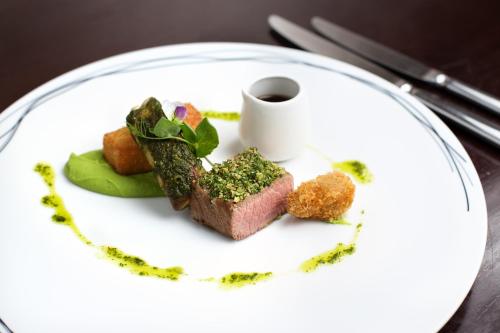 a white plate with food on a table at Mangapapa Hotel in Havelock North