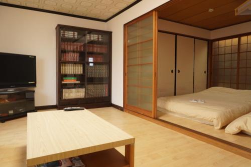 a room with a bed and a tv and a table at Villa alive in Takekara