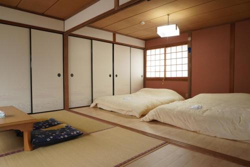 a room with two beds and a table in it at Villa alive in Takekara