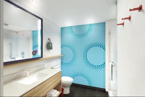 bagno con servizi igienici e parete blu di Tru By Hilton Edinburg a Edinburg