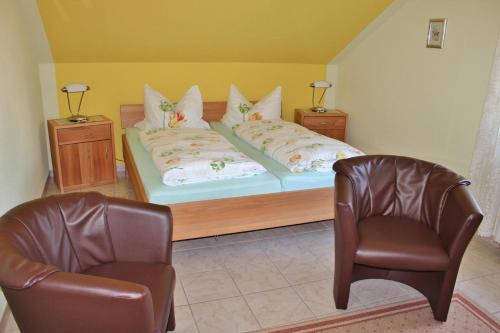 a bedroom with a bed with two chairs and two beds at Pfaelzer Stuben in Landstuhl