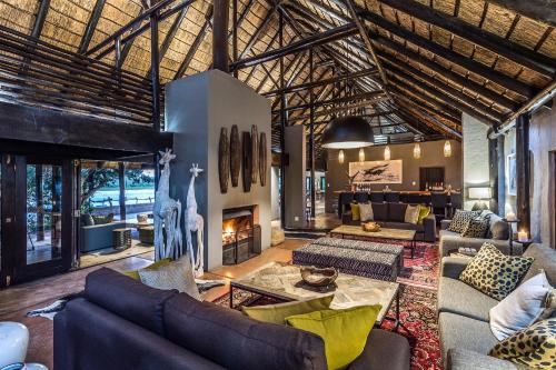 Una gran sala de estar con sofás y chimenea. en Kariega Game Reserve River Lodge, en Kenton on Sea