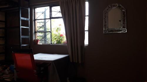 ventana en una habitación con mesa y espejo en El laberinto hospedaje en casa en Morelia