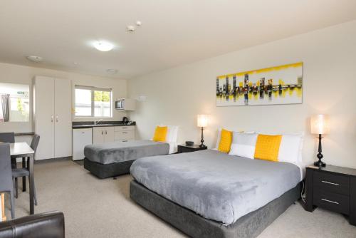 a hotel room with two beds and a kitchen at Ellena Court Motel in Blenheim