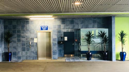 a lobby with a door and two palm trees at Best Western Wellington in Johnsonville