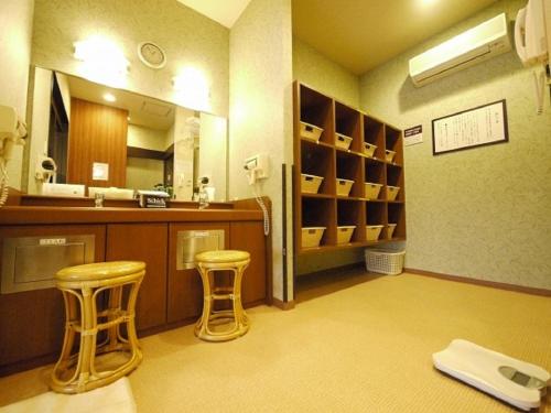 a kitchen with two stools and a sink and a mirror at Hotel Route-Inn Shimodate in Chikusei