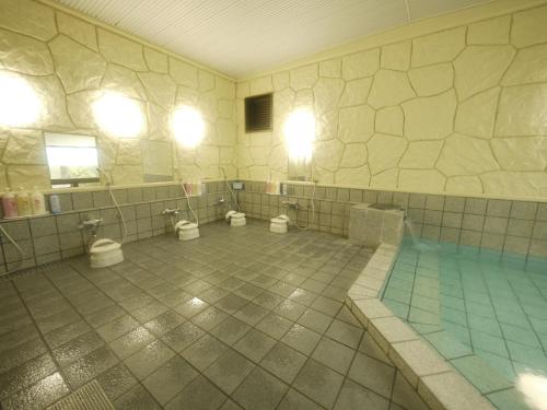 a bathroom with three toilets and a swimming pool at Hotel Route-Inn Court Minami Alps in Minami Alps