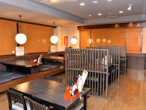 a restaurant with wooden tables and chairs and a table and tablesktop at Hotel Route-Inn Court Minami Alps in Minami Alps